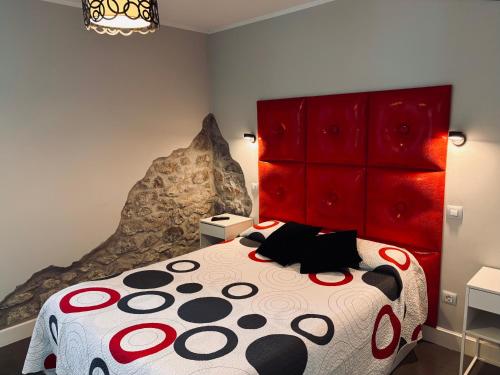 a bedroom with a large bed with a red headboard at Apartamentos Villa Fresnedo in Solares