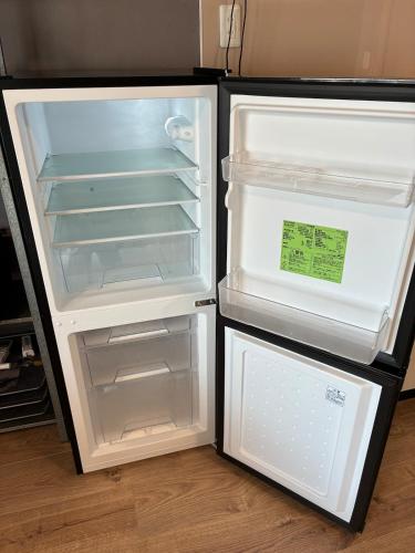 an empty refrigerator with its door open in a kitchen at NagataSeaTime in Yakushima