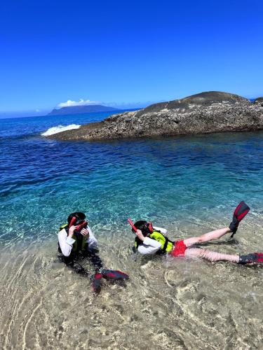 two people laying in the water on a beach at NagataSeaTime in Yakushima