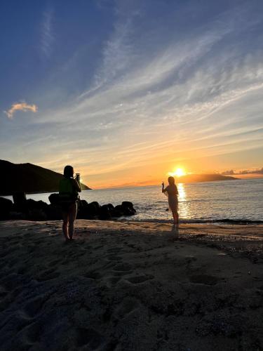 two people standing on the beach at sunset at NagataSeaTime in Yakushima