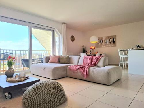 a living room with a couch and a table at Duplex Villa Capricia appartement met zwembad Nieuwpoort Jachthaven in Nieuwpoort