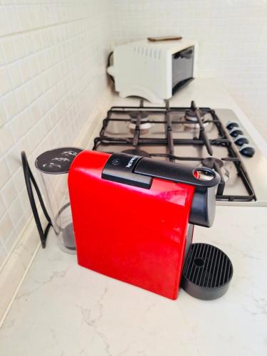 a red toaster sitting on top of a stove at Il Carrubo&Castagno Casette vacanza in Villaggio Azzurro