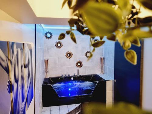La salle de bains est pourvue d'une baignoire bleue. dans l'établissement Orphelin2 balnéo plaisir & détente au centre ville, à Reims