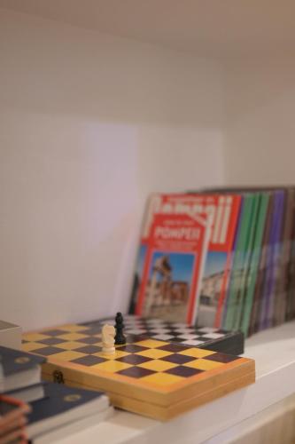a chess board sitting on a table next to a book at L'Anfiteatro di Pompei B&B in Pompei