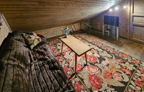 a room with a bed and a table on a rug at Beautiful Home In Nesbyen With Sauna in Nesbyen