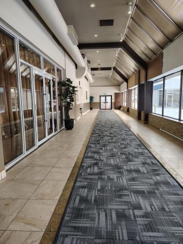an empty hallway in a building with a rug on the floor at The Lodge Inn in Edmonton