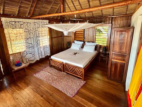 a bedroom with a bed with a canopy at Antoremba Lodge in Ankify
