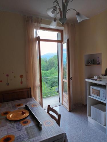 a dining room with a table and a sliding glass door at Zumaglia Home in Zumaglia