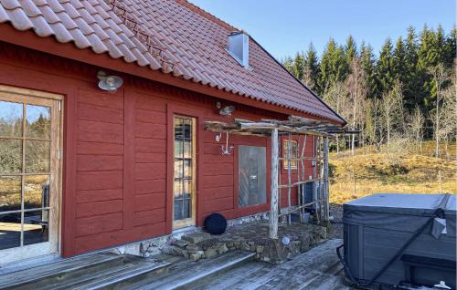a red house with a front door and a grill at Gorgeous Home In Ydre With Sauna in Hult