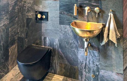 a bathroom with a copper sink and a toilet at Gorgeous Home In Ydre With Sauna in Hult