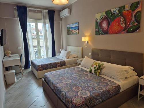 ベルパッソにある"La città delle 100 sculture" B&B BcenS con parcheggio privato - Belpasso - Etna -のベッド2台とソファがあるホテルの部屋