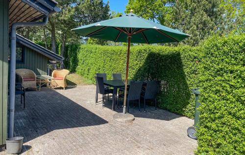 a table and chairs under an umbrella on a patio at 3 Bedroom Beautiful Home In Hørve in Hørve