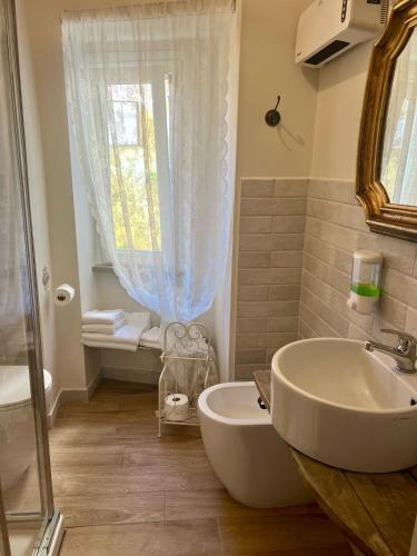 a bathroom with a sink and a toilet and a window at le Piagge in Viterbo