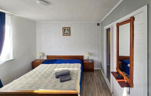 a bedroom with a bed with blue sheets and a window at Gorgeous Apartment In Rörvik With Wifi in Rörvik