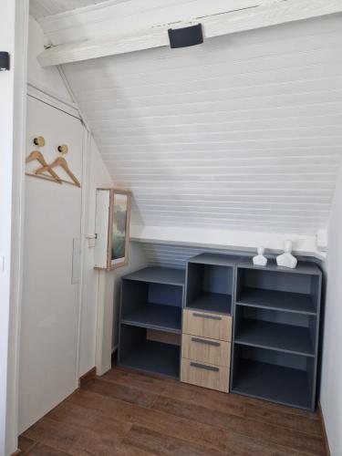 an attic room with a blue desk and a white ceiling at Les G in Gasny