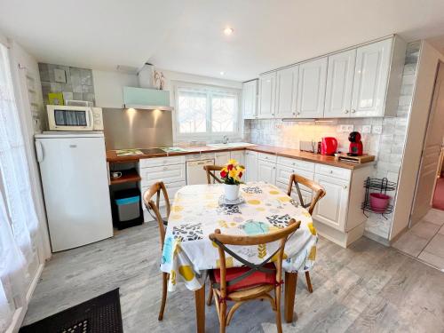 une cuisine avec une table, des chaises et un réfrigérateur dans l'établissement Le Neptune, Calme, Centre-ville, à Royan