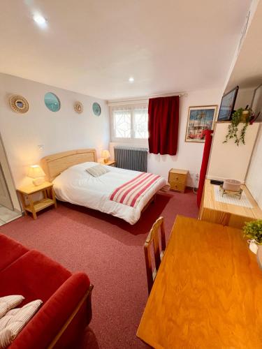 une chambre avec un lit et une table dans l'établissement Le Neptune, Calme, Centre-ville, à Royan