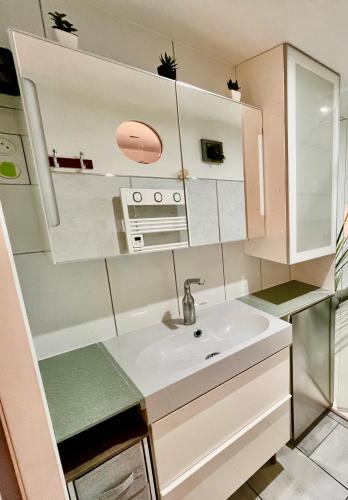 une petite cuisine avec un évier et un micro-ondes dans l'établissement Le Neptune, Calme, Centre-ville, à Royan