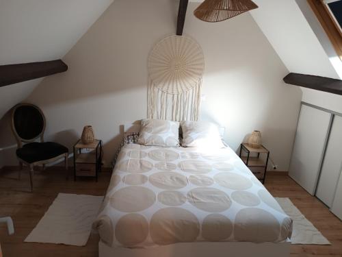 a bedroom with a large white bed and two chairs at Appartement cosy in Vic-sur-Aisne