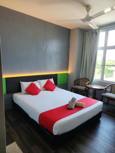 a bedroom with a large bed with red and green pillows at Lucky Hotel in Sungai Petani