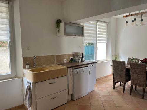 une cuisine avec un évier et une table avec des chaises dans l'établissement Latour des Sens, à Pont-Saint-Esprit