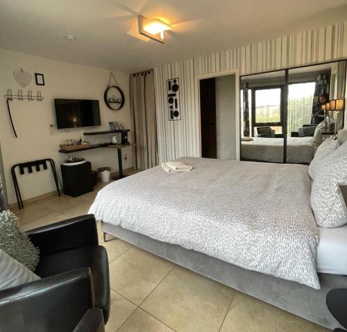 a bedroom with a large bed and a television at B&B Le Bouchat-Oreille in Spontin