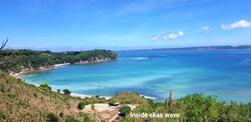 a view of a beach with blue water and trees at Ombak Resort at Ekas , a luxury surf and kite destination, Close to Inside Ekas beach in Ekas