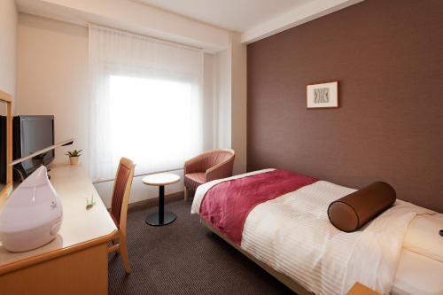 Een bed of bedden in een kamer bij Ueda Tokyu REI Hotel