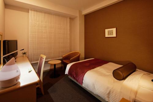 a hotel room with a bed and a desk at Ueda Tokyu REI Hotel in Ueda