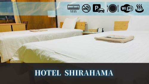 two beds in a hotel shirmka with towels on them at Hotel shirahama in Shirahama