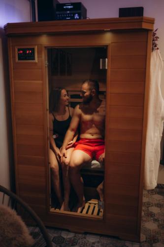 a man and a woman are sitting in a cabinet at Polehárna soukromý wellness apartmán in Ústí nad Labem
