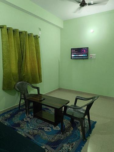 una sala de estar con una mesa y dos sillas en Patliputra Vihar, en Patna