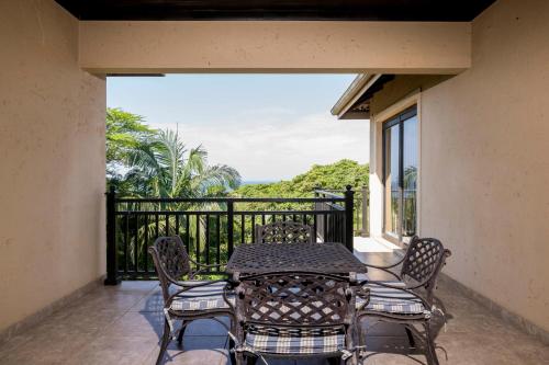 a patio with a table and chairs on a balcony at Marion Views in Ballito