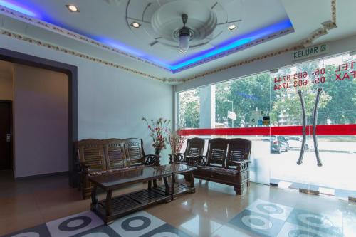 a room with chairs and a table and a window at Valley View Hotel in Lumut