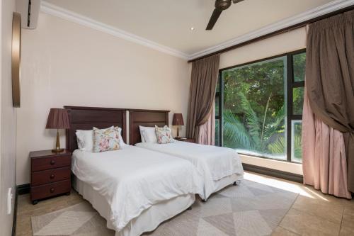 a bedroom with a bed and a large window at Marion Views in Ballito