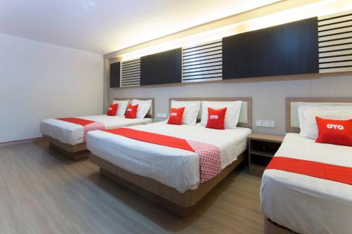 a hotel room with two beds with red pillows at Valley View Hotel in Lumut