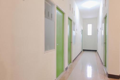 a corridor of a hospital with green and white walls at Hotel O Antosa Family Residence in Jember