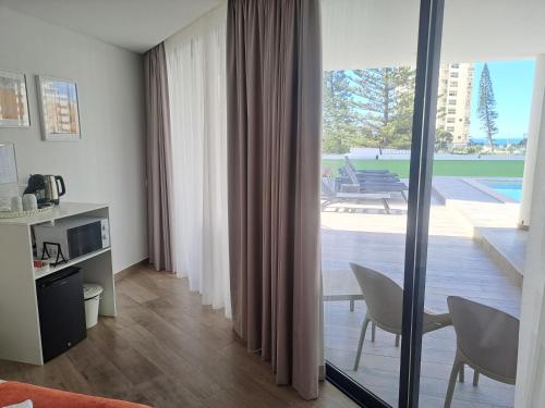 a living room with a sliding glass door to a patio at AlgarPapa Rooms in Armação de Pêra