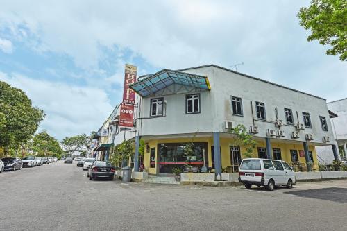 a building on the side of a street with cars parked at Hotel O De Perdana Hill in Batu Pahat