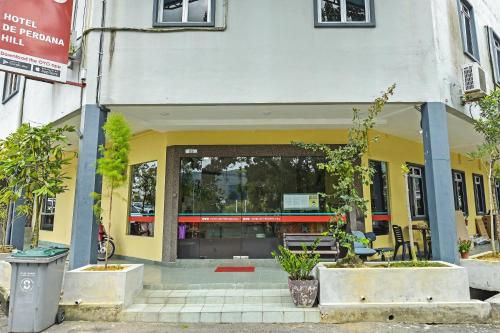 a store front of a building with trees in front at Hotel O De Perdana Hill in Batu Pahat