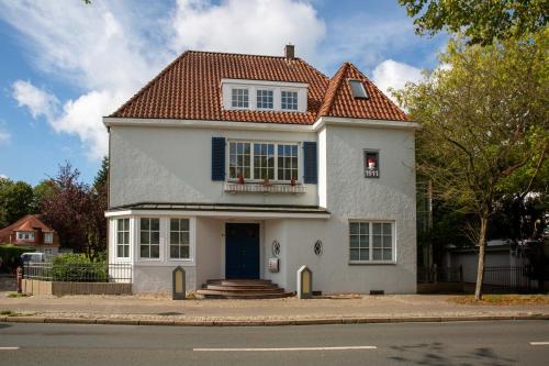 a white house with a red roof at --- studio19elf --- Ferienwohnung in Delmenhorst Stadtmitte in Delmenhorst