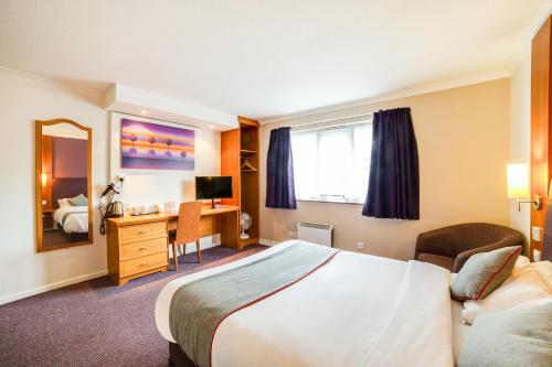 a hotel room with a bed and a desk at OYO Lakeside Haydock Hotel, St Helens, A580 East Lancs, Garswood Old Road in Saint Helens