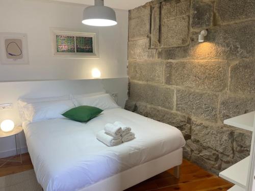 a bedroom with a bed with towels on it at APARTAMENTOS "Plaza de la Iglesia" in Vigo