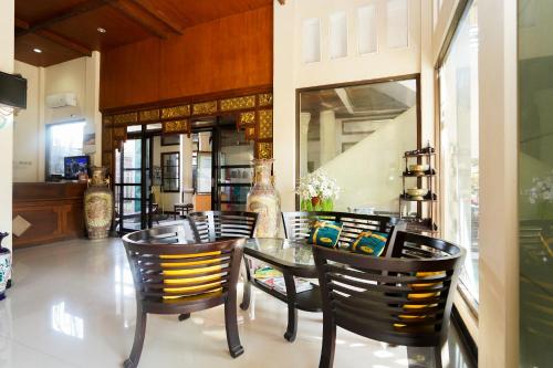 a dining room with a glass table and chairs at Capital O 1430 Hotel Ratna Syariah in Probolinggo