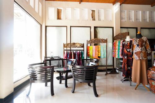 a clothing store with chairs and clothes on display at Capital O 1430 Hotel Ratna Syariah in Probolinggo