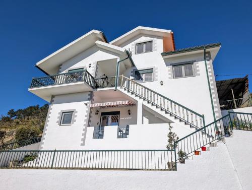 a white house with stairs in front of it at Bela Vista in Paradela