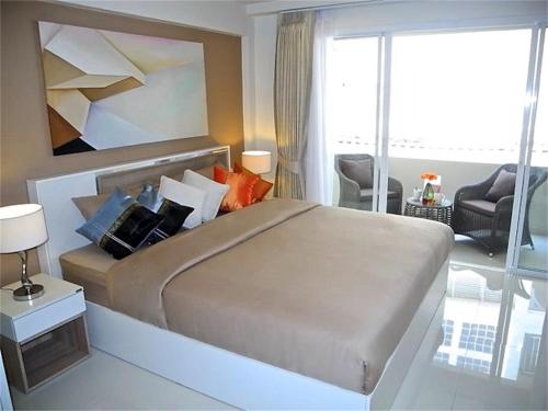 a bedroom with a large bed and a living room at Kata Plaza 1 bedroom Modern Apartment in Kata Beach