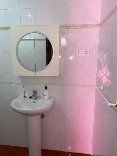 a pink bathroom with a sink and a mirror at Casa Cris in Aracena