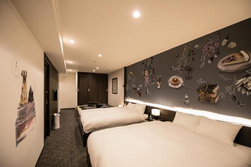 a hotel room with two beds and a black wall at Randor Residence Kyoto Nijo Castle in Kyoto