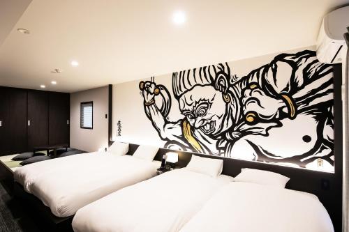 two beds in a room with a mural on the wall at Randor Residence Kyoto Nijo Castle in Kyoto
